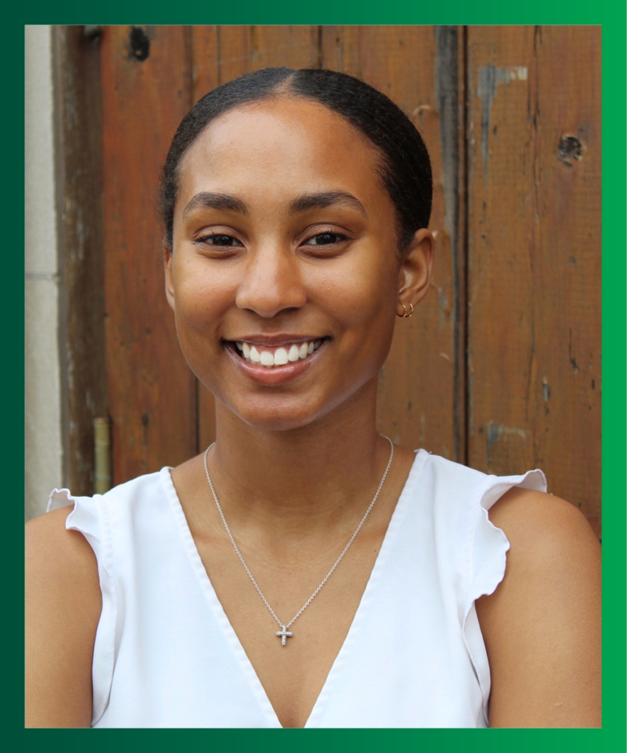 Picture of Jordan P., smiling Black female,  with white sleeveless blouse and black, slicked-back ponytail with middle part.