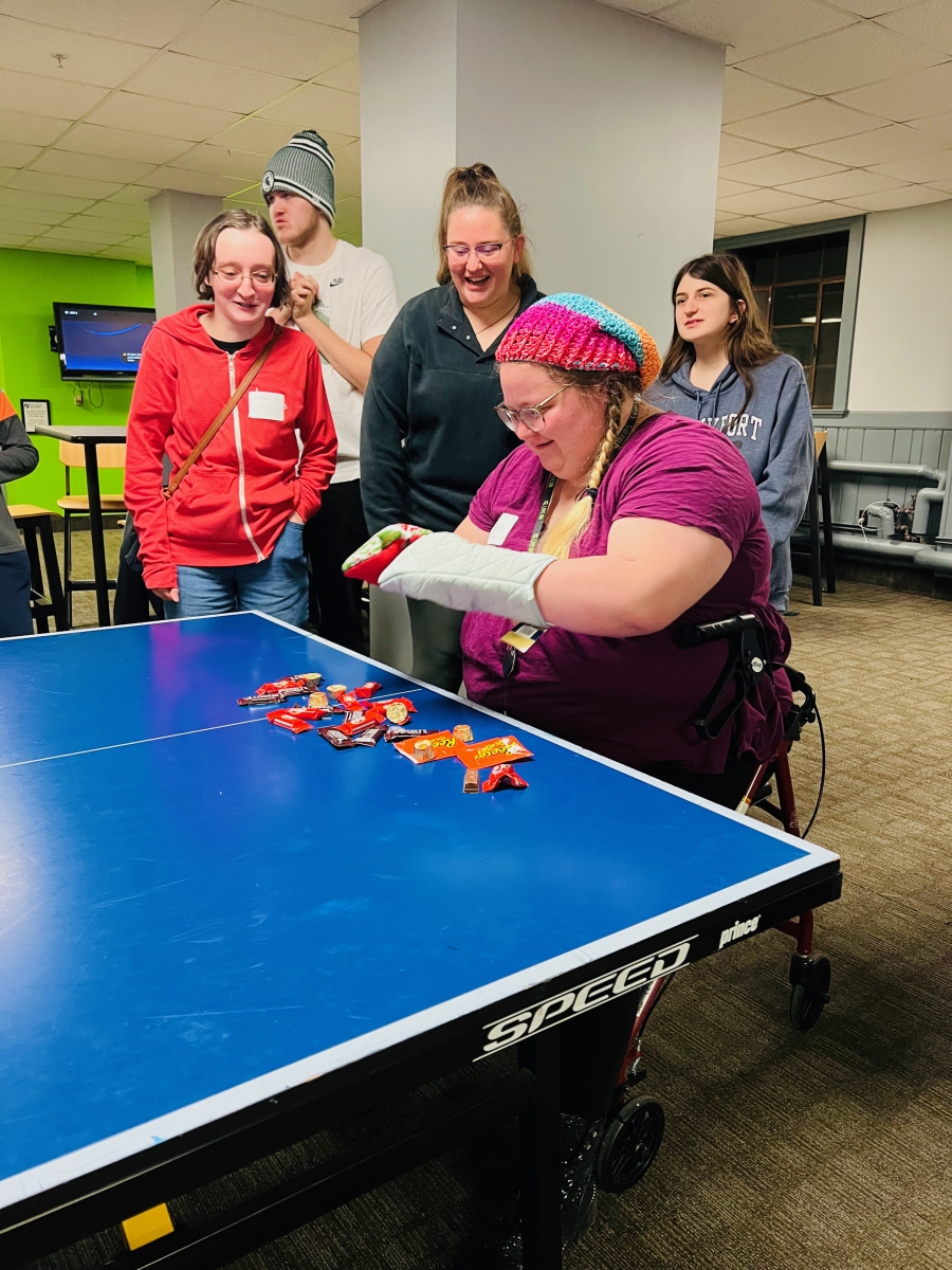 Group of students gathered around a table playing a game.