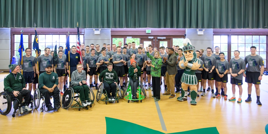 Runners and Rollers along with Sparty and interim MSU President pose for a photo at Landing ceremony