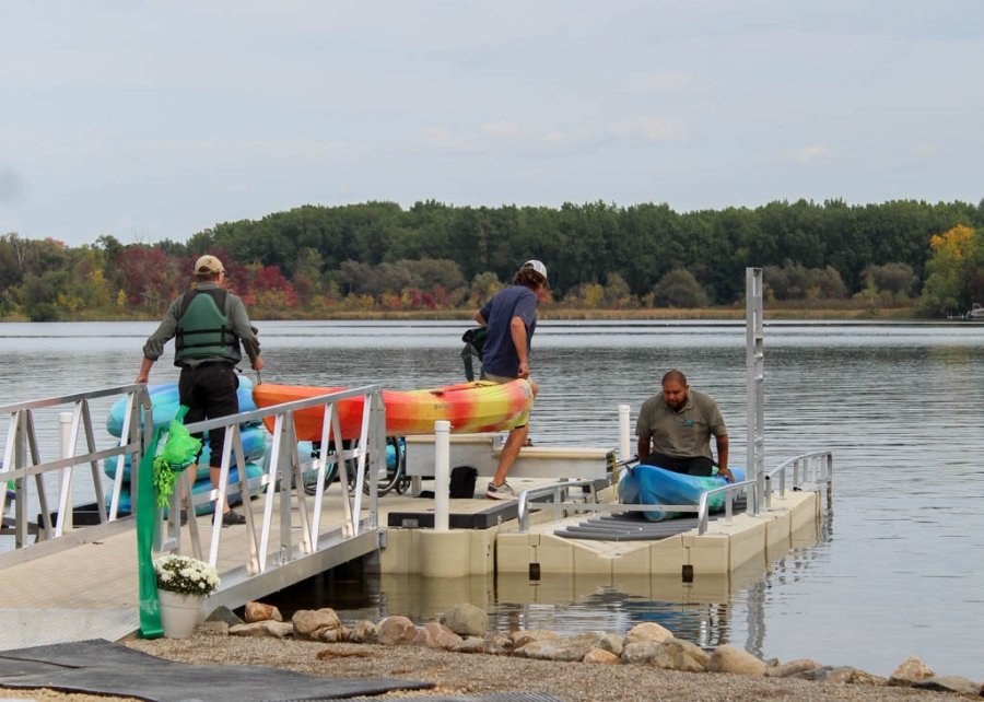 Photo of Robert Briseno using accessible dock and getting himself into a kayak.