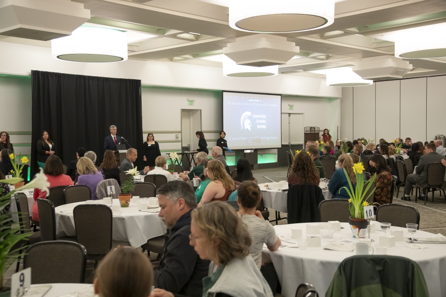 Awards Reception Room with Guests sitting at Tables and Mike Hudson Speaking at Podium