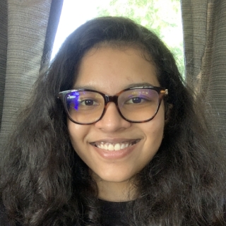 Photo of Surabhi Gangadkar: A woman with long, dark hair, wearing glasses and a dark colored shirt.